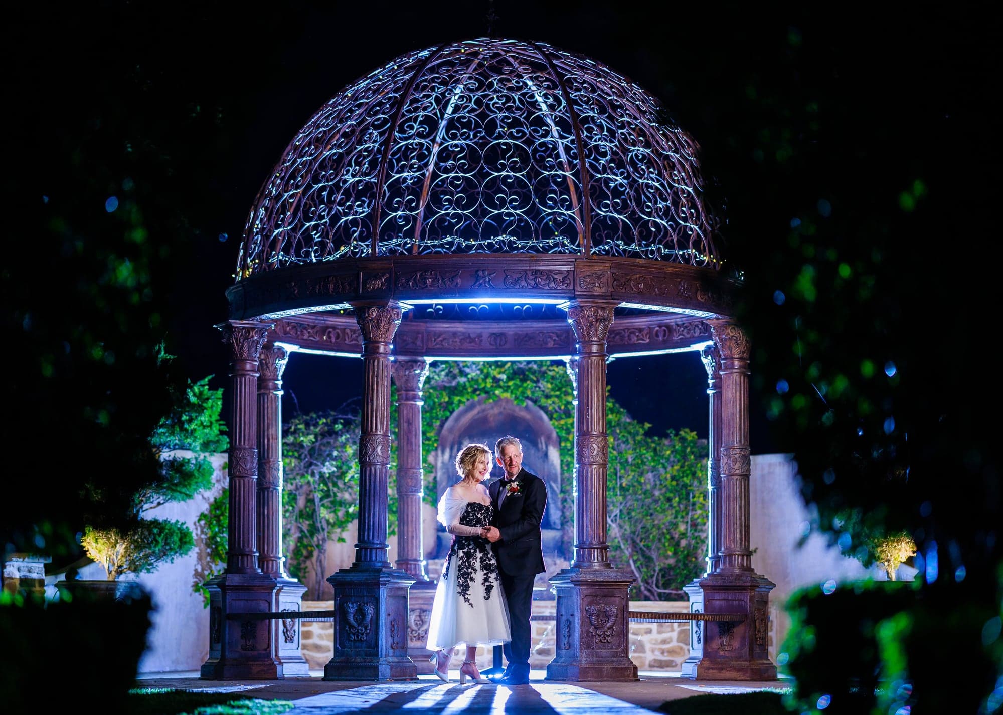 Donna and Greg beneath the illuminated gazebo at night