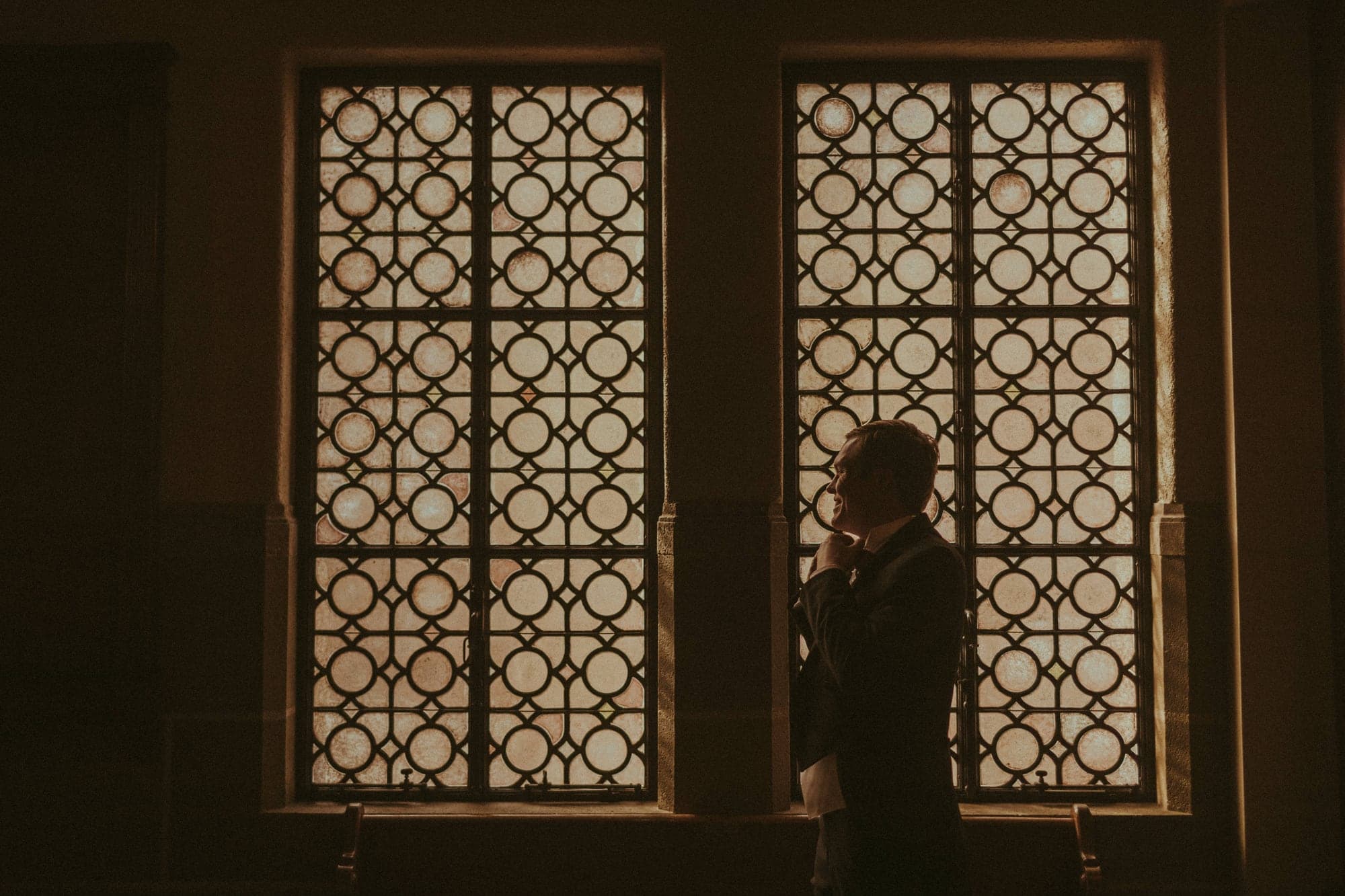 Groom preparing in window light before the Swartz ceremony
