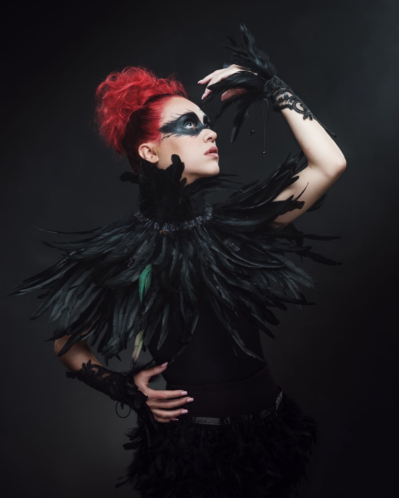 Avant-garde studio portrait of a woman with sculpted red hair and a black feathered collar, photographed on Fujifilm GFX