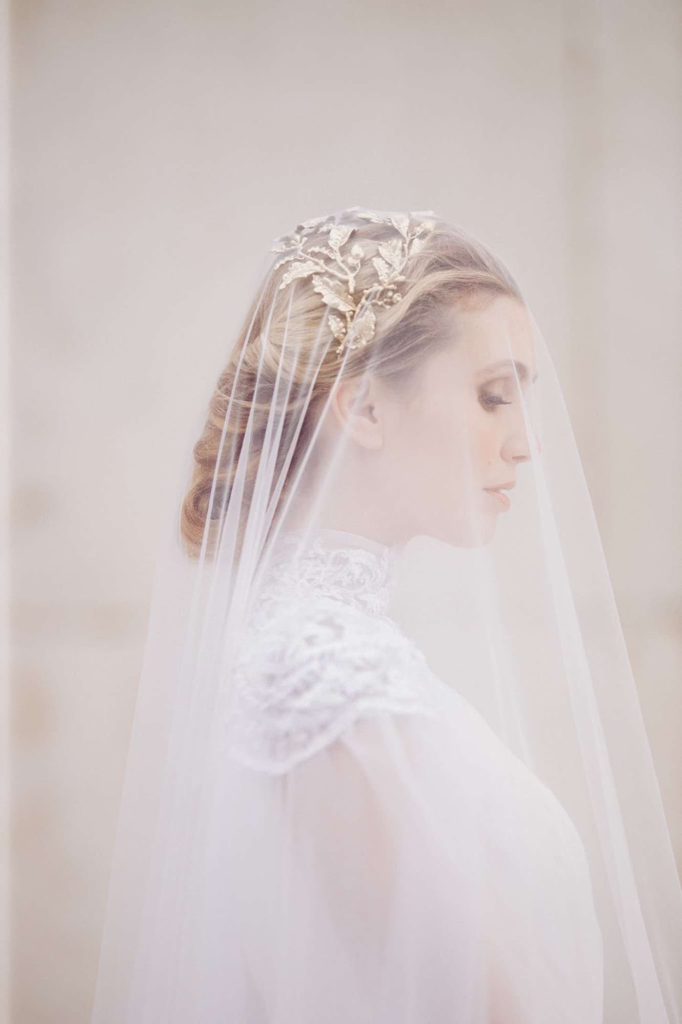 A soft, backlit bridal portrait of a veiled bride emphasizing natural skin tones, photographed on the Canon EOS R
