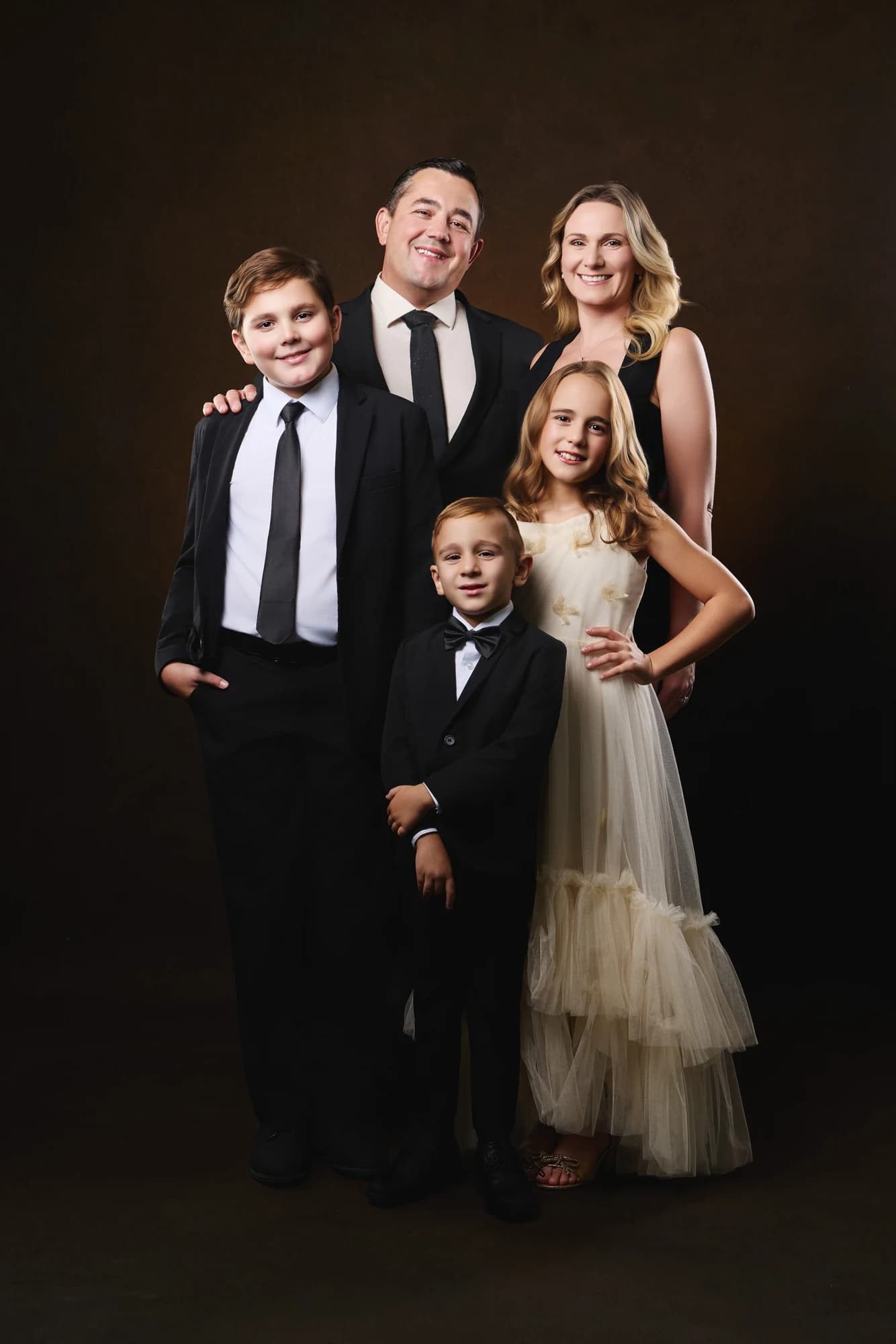 A family of five together in a formal studio portrait