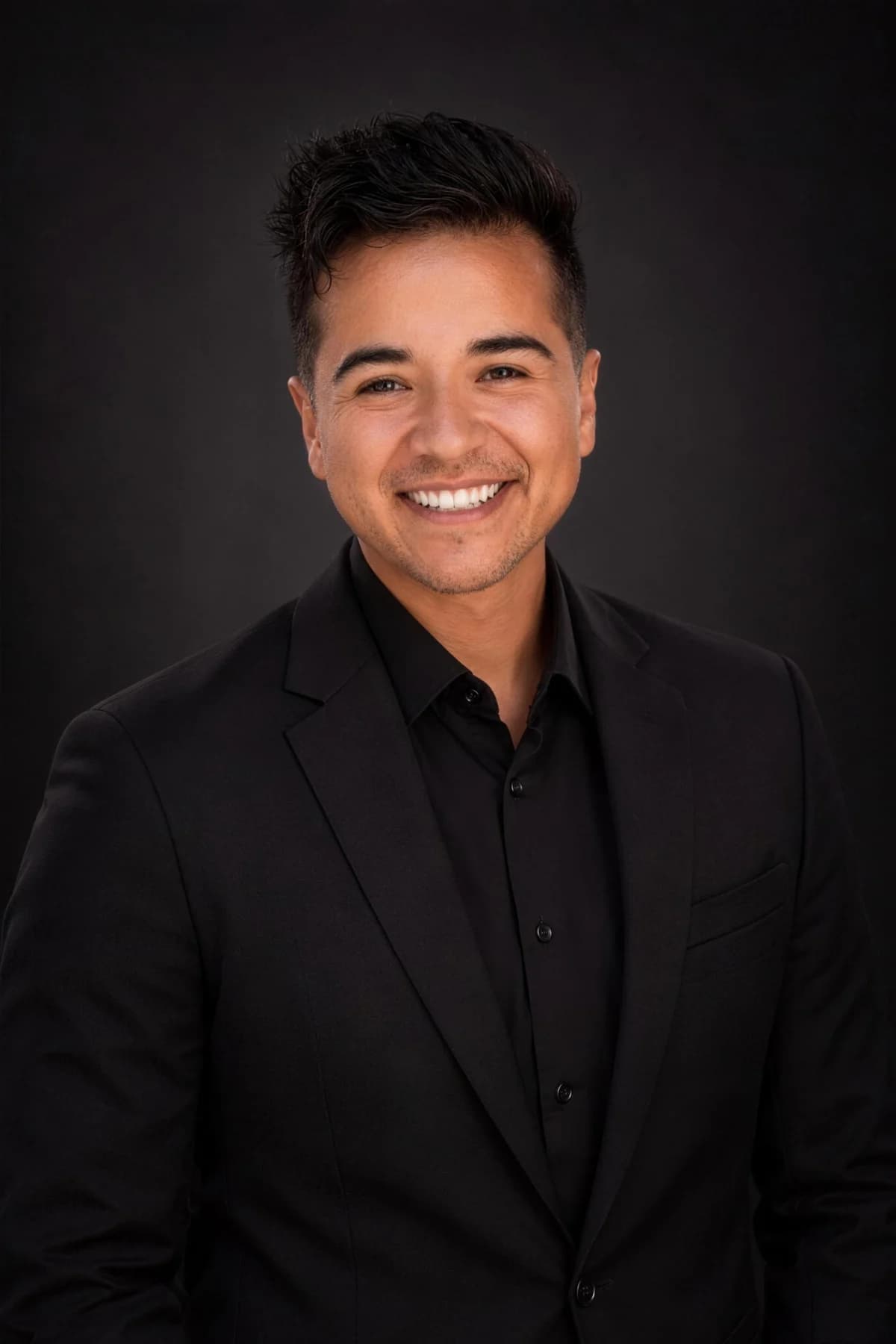Hunter in a black suit against a dark studio backdrop